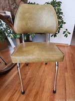 Front view olive green vinyl chair on hardwood floor