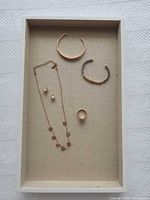 Tray containing two bangles, necklace, earrings, and ring