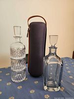 Front view of both decanters with stoppers and carrying case