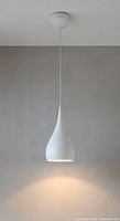 Full view of the teardrop pendant light hanging from ceiling showing matte white finish and shape