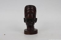 Front view of carved bust showing facial features and finish