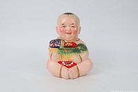 Front view of porcelain child piggy bank holding carp