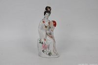 Front view of porcelain lady figurine holding drum