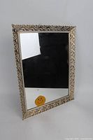 Front view of rectangular gold-tone ornate framed mirror