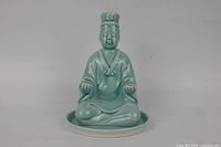Front view of seafoam glazed seated figure on white base