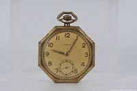 Front view showing octagonal case, cream dial, Arabic numerals, subsidiary seconds