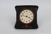 Front view of Waltham travel clock in open case showing dial and numerals