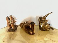 Three animal head wall mounts on surface
