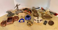 Wide view of assorted ashtrays, lighters and figurines