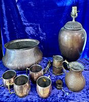 Group shot of all copper items including lamp, planter, mugs, pitcher, tankard, prayer wheel