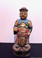 Front view of polychrome carved wood dignitary figure on round base