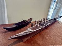 Both wooden canoe models side by side on surface