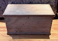 Full frontal view of rectangular unfinished trunk showing lid, front panel, base molding