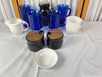 Group view of all mugs, canisters, creamer and bowl