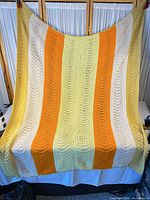 Full view of crocheted throw blanket showing size and stripe pattern