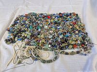 Overview of entire pile of beads and findings on white cloth