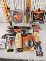 All eleven packaged BBQ and kitchen accessories displayed on table