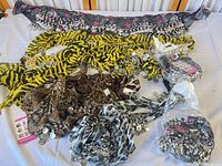 All nine scarves laid out displaying patterns and coin fringe
