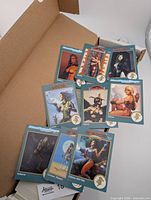 Cards spread on top of box showing fronts with teal borders and fantasy artwork