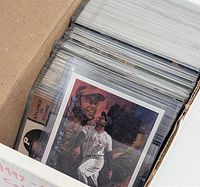 Box of sleeved baseball cards showing Willie Mays card at front