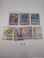 Seven sleeved Pokémon GX full art cards laid out on white background