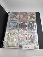 Binder open showing nine cards per page of Weiss Schwarz Marvel set