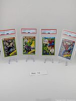 All four PSA graded Marvel Universe cards on stands