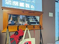 Front view of wall mirror showing wood frame, inset glass, and hooks