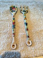 Front view of spoon and fork showing painted floral design and overall length