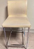 front view of stool showing leather upholstery and chrome frame