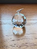 Front view of faceted crystal apple on wood surface