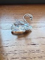Left profile of faceted crystal swan showing body facets and smooth neck