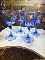 Four blue etched water goblets standing on table