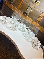 Four stemmed snifter glasses and two star tealight holders arranged on table