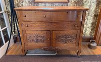 Front view of oak chest showing drawers, carved doors, overall design