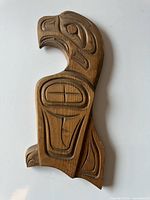 Front view of carved wood Thunderbird plaque