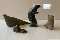 Group view of four signed soapstone animal carvings