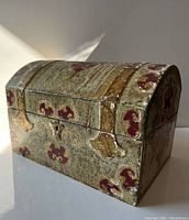 front angled view showing gold and red scrollwork, domed lid, keyhole