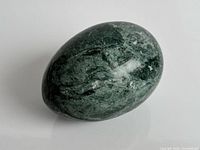 Oblique view of polished dark green stone egg