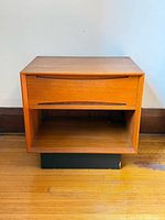 Front view showing drawer, open shelf, and base