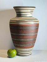 Full view of vase beside apple for scale