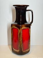 Full view of tall red and brown glazed floor vase