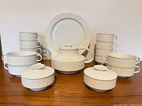Complete set arranged: teapot, sugar bowls, dinner plate, cups, soup bowls