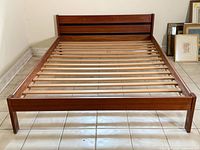 Full view of assembled teak queen bed frame with headboard, footboard and slats visible