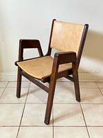 three-quarter view of armchair showing wood frame, vinyl upholstery