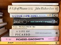 Stack of eight Picasso related books showing spines