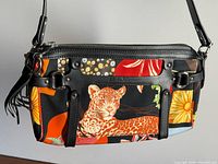 Front view showing jungle print leopard motif, leather trim, zipper and hardware