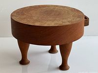 Full view of stool side profile showing round top and three legs