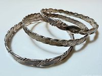 Three sterling silver bangles stacked, showing overall design and condition