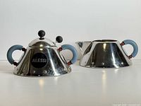 front view of sugar bowl and pitcher showing handles and finish